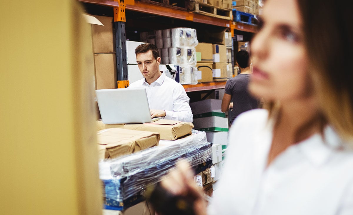 Man on a laptop in a warehouse using NetSuite support